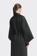 Black MS. Doll coat by Stolen Stores displayed on a mannequin, featuring a stylish design with a tailored fit.