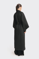 Black coat from the MS. DOLL collection by Stolen Stores, featuring stylish design and tailored fit, shown on a mannequin.
