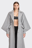 Gray coat from Stolen Stores' Ms. Doll collection displayed on a hanger, showcasing the stylish design and fabric details.