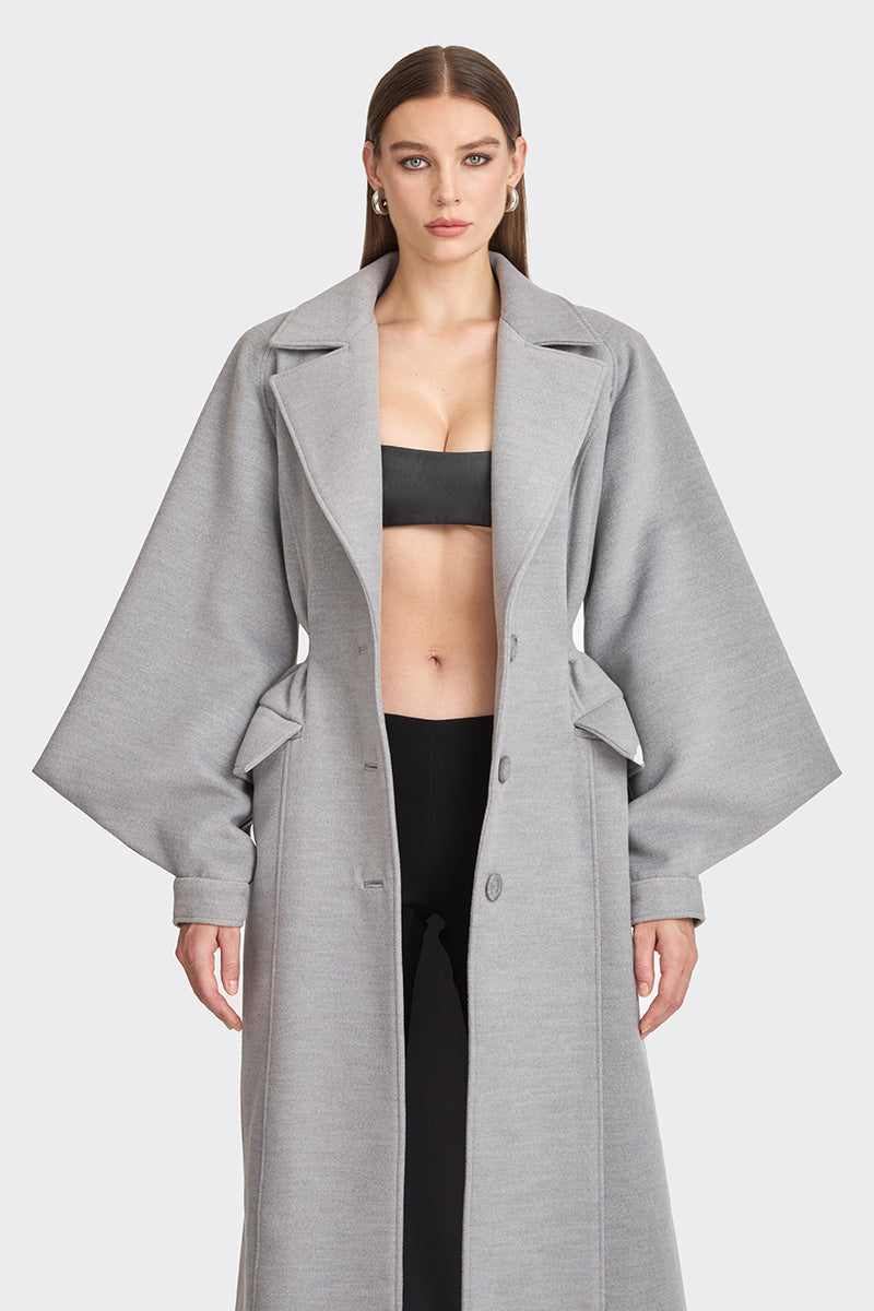 Gray coat from Stolen Stores' Ms. Doll collection displayed on a hanger, showcasing the stylish design and fabric details.
