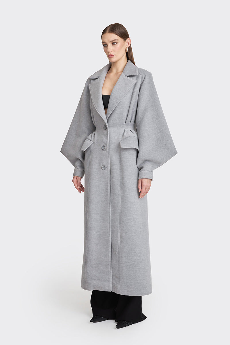Gray coat from Stolen Stores' Ms. Doll collection displayed on a hanger, featuring a stylish and modern design.