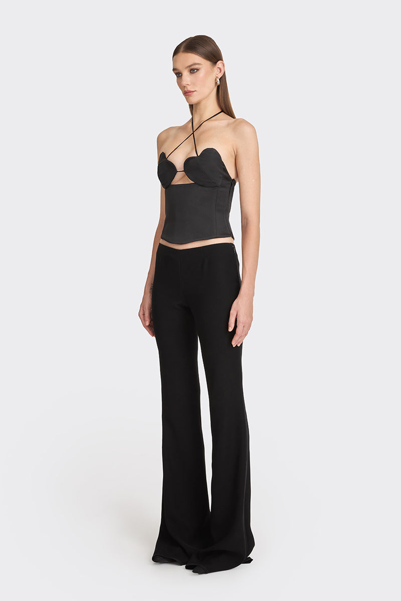 Black side bustier top from Stolen Stores with structured design and adjustable straps, shown on a model.