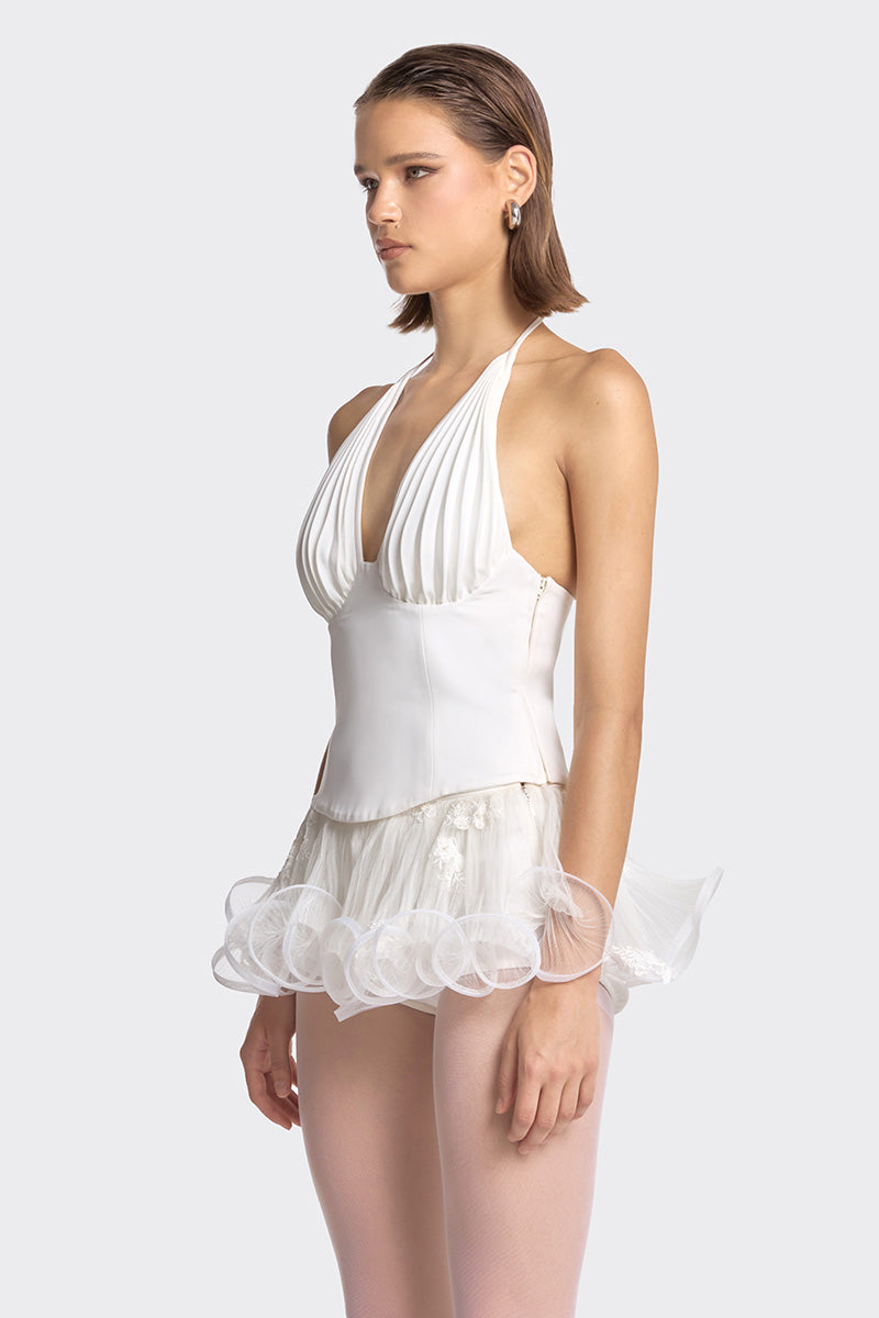White MS. Pleat corset top by Stolen Stores, featuring structured pleats and a fitted design, shown on a mannequin.