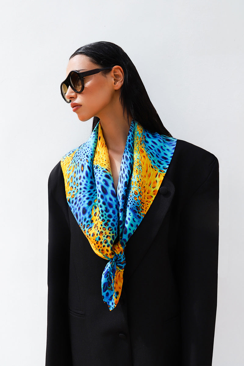Elegant silk scarf by Amel Batita featuring the Munir Moussard design, displayed folded with intricate patterns and vibrant colors.