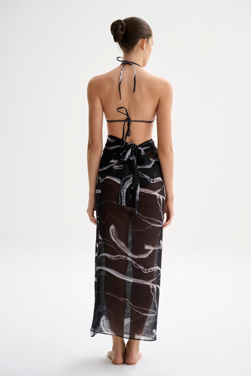 Nelblu black print pareo skirt, a stylish cover-up featuring a vibrant print, perfect for beach or poolside wear.