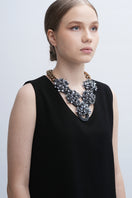 Gray Greta necklace by Aidan & Ice featuring a delicate chain and minimalist pendant on a plain background.