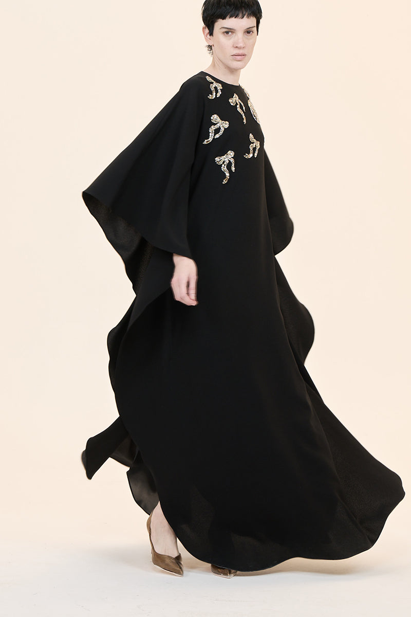 Nihan Peker NEEHAL Batwing Gown in flowing fabric with batwing sleeves, elegant design, shown on a model.