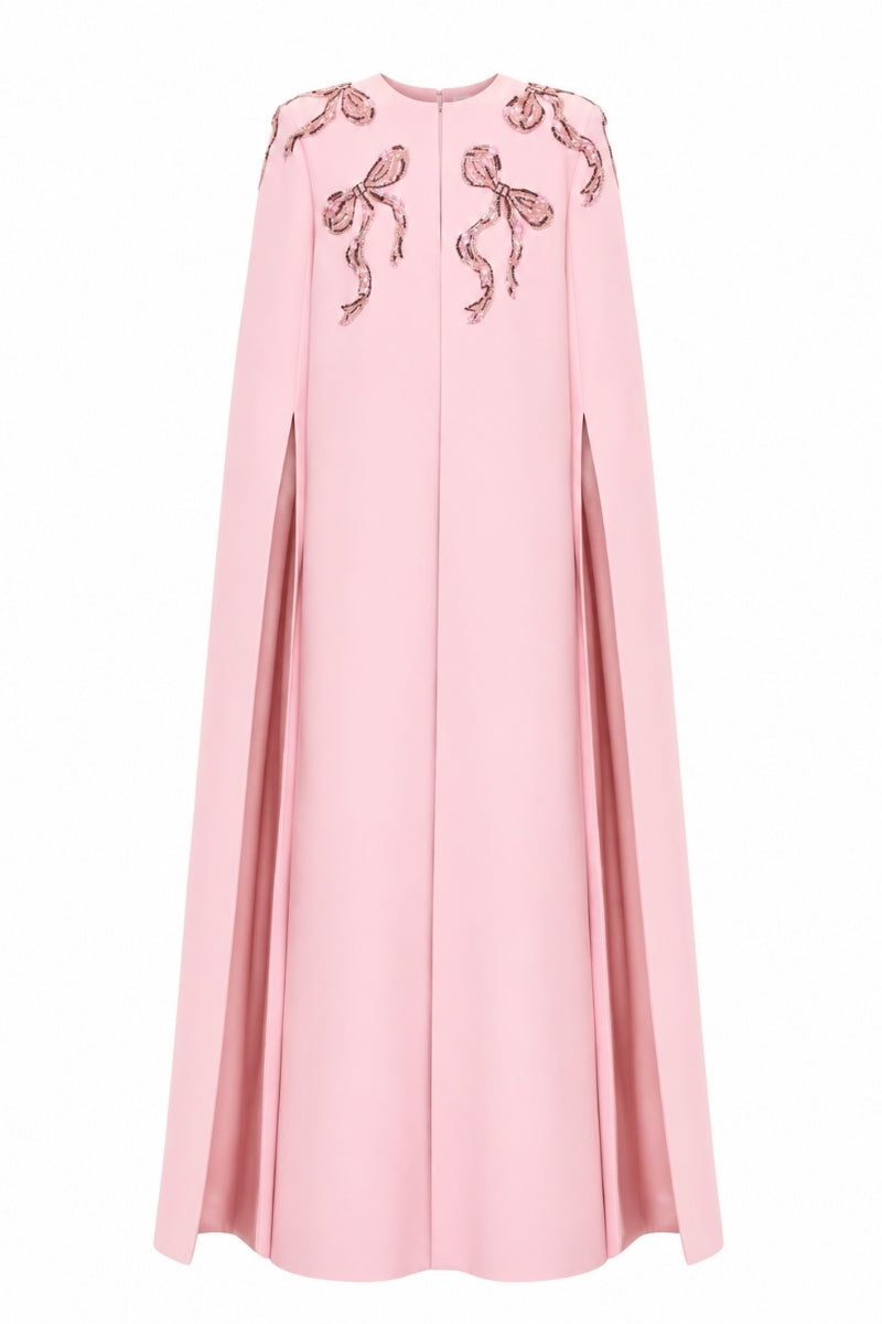 Pink cape gown by Nihan Peker featuring flowing fabric and elegant design, perfect for formal events or fashion shows.