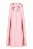 Pink cape gown by Nihan Peker featuring flowing fabric and elegant design, perfect for formal events or fashion shows.