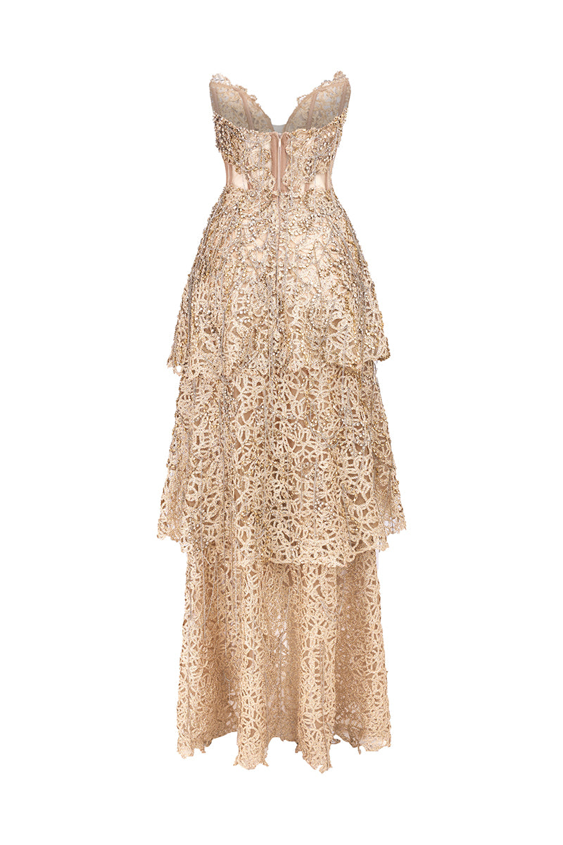 Deep gold V-neck corset gown by Phan Huy with metallic bead embroidery and playful fringe details, shown from the back.