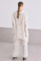 Light beige NUNO lace culotte trousers by MAZ Manuela Álvarez, shown on a model with a relaxed fit and lace detailing.