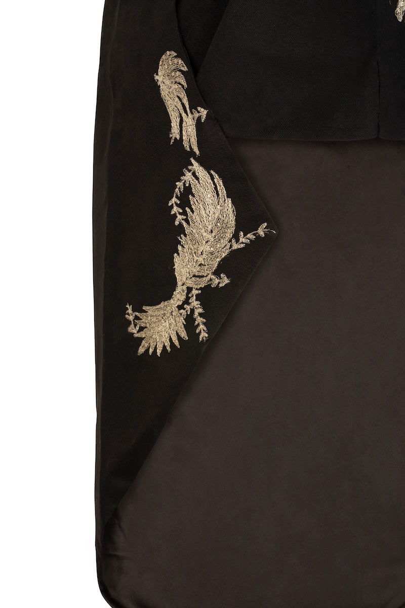 Nadya Shah Phoebe Cape jacket in soft fabric with wide collar and draped design, shown in a stylish outdoor setting.