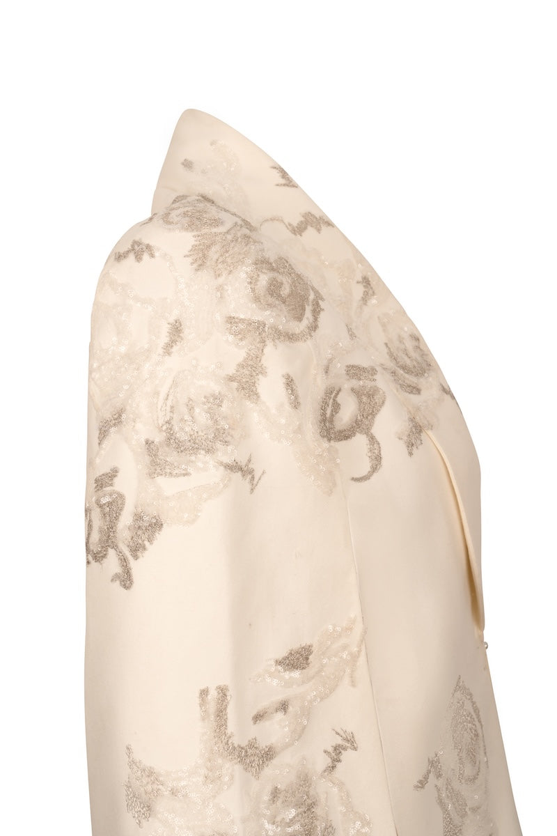 Nadya Shah Lumiere Cape jacket displayed on a hanger, showcasing its elegant design and fabric details.