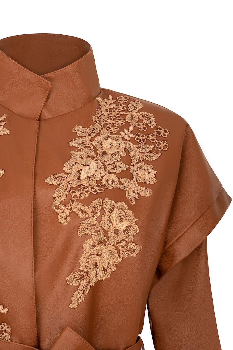 Nadya Shah CLEO faux leather belted jacket displayed on a hanger, showcasing its sleek design and belt detail.