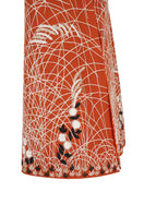 Nadya Shah clementine-colored cape jacket with flowing fabric and stylish design, perfect for layered winter or fall outfits.
