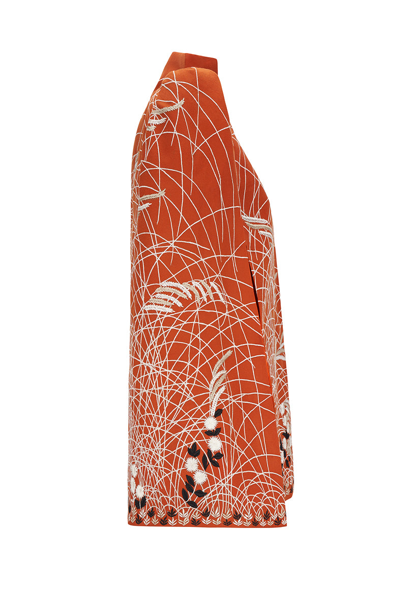 Nadya Shah clementine-colored cape jacket with flowing fabric and stylish design, perfect for layered fall or winter wear.