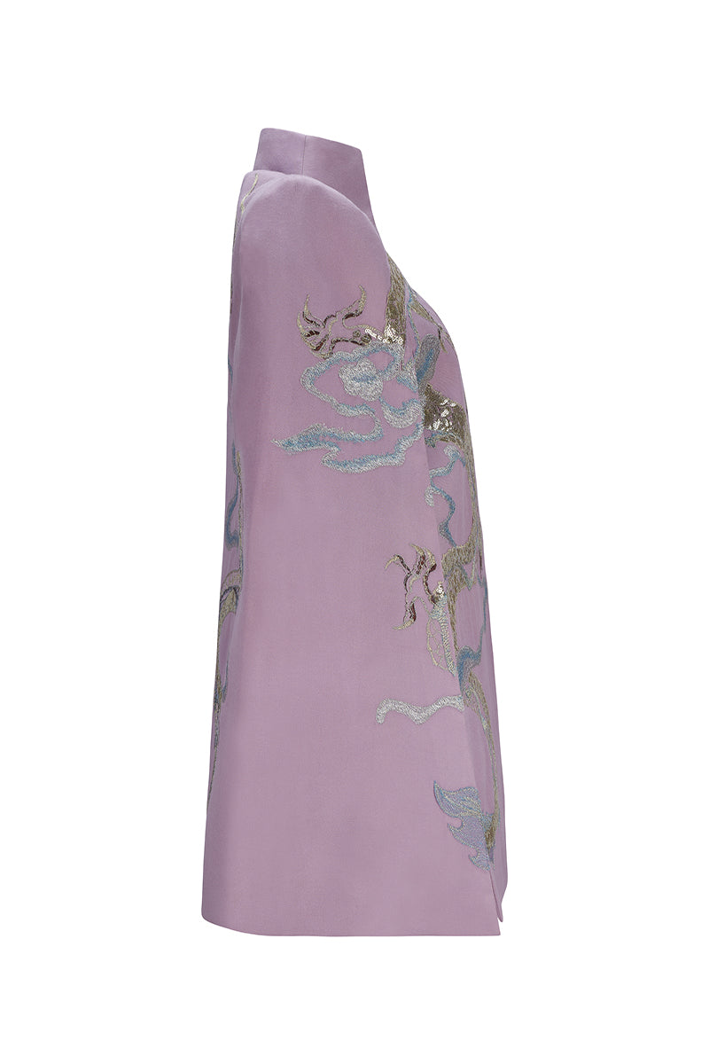 Nadya Shah Hydra Lilac Cape jacket shown hanging on a mannequin, featuring soft lilac fabric and elegant design.