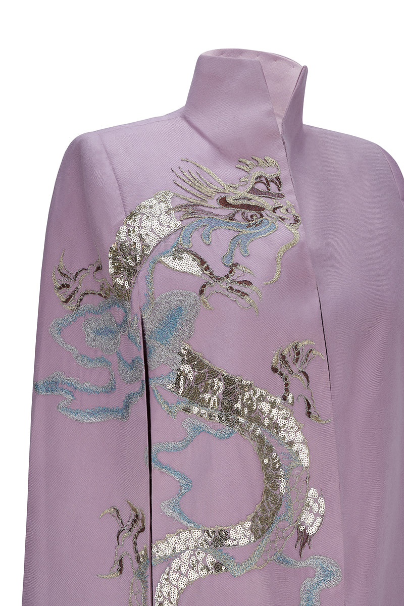 Nadya Shah Hydra Lilac Cape jacket shown on a model, featuring soft lilac fabric and stylish draped design.