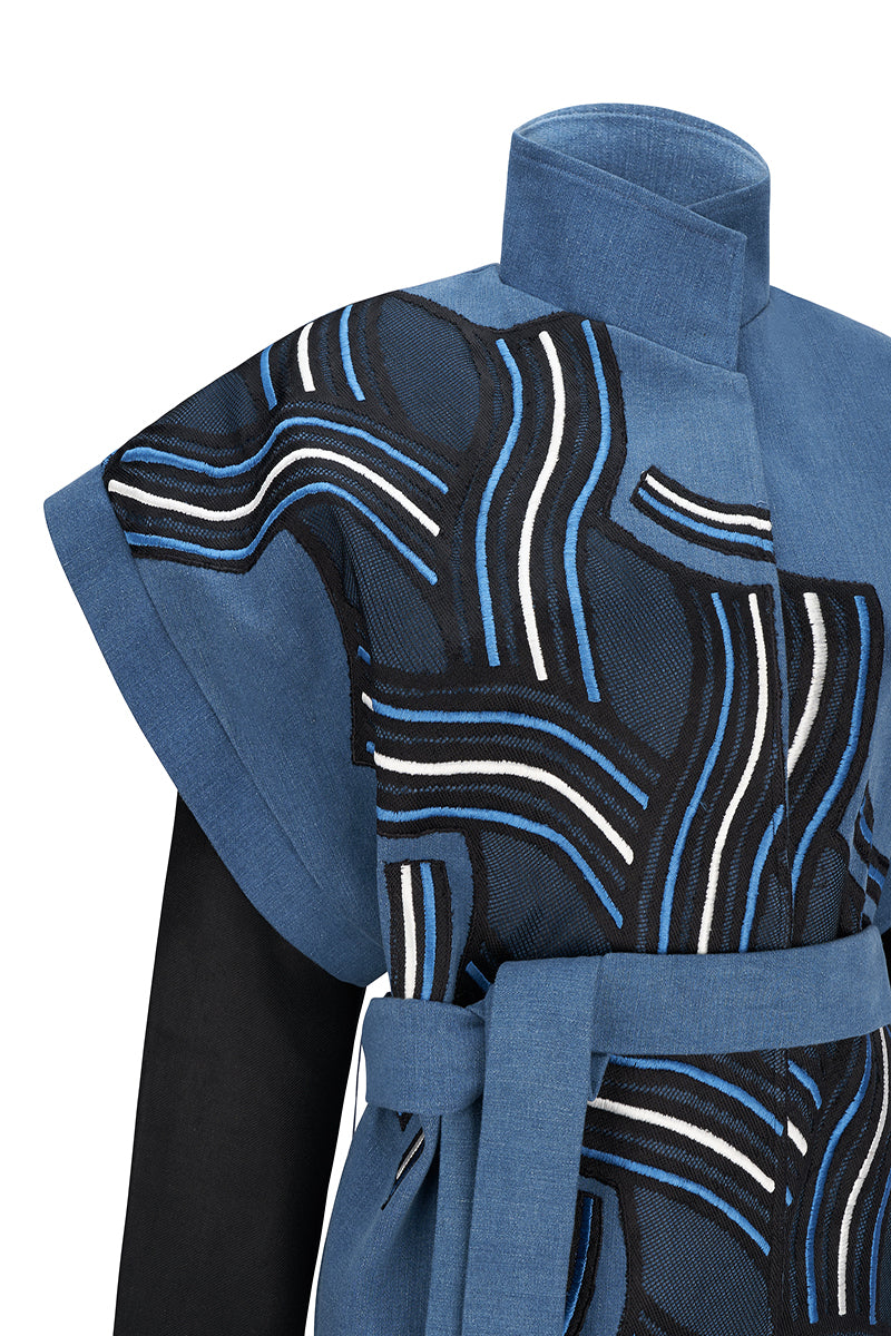 Nadya Shah twist denim jacket with classic collar, button closure, and stylish distressed details on a model.