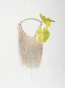 White Neus crochet shoulder bag by Millanne Tale, stylish and spacious accessory with a woven design and shoulder strap.
