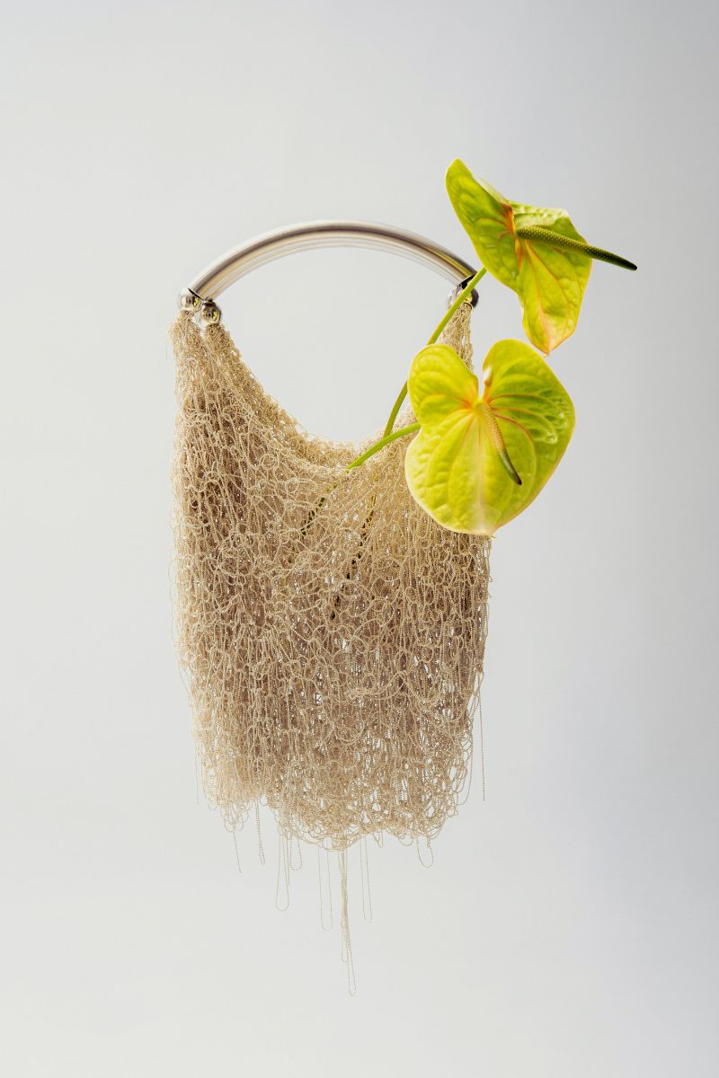 White Neus crochet shoulder bag by Millanne Tale, stylish and spacious accessory with intricate crochet design.