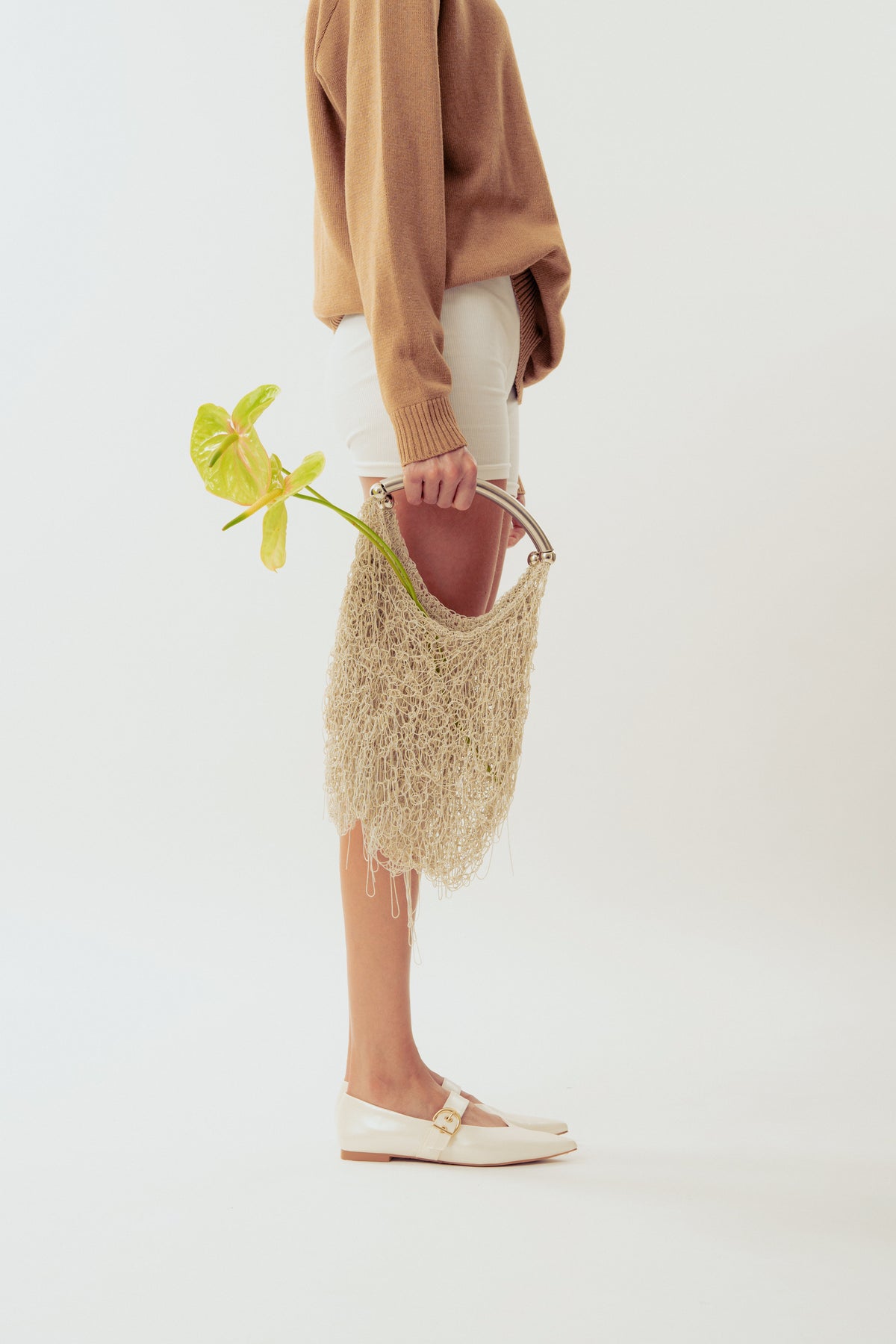 White Neus crochet shoulder bag by Millanne Tale, stylish and compact with a woven design and shoulder strap.