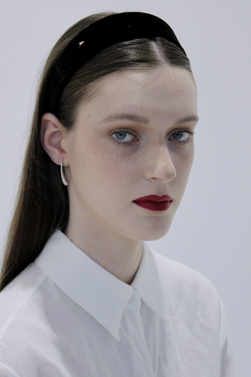 A pair of elegant sterling silver earrings by Aethera with a sleek, minimalist design on a plain background.