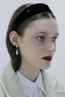 Silver toned earrings by Aethera featuring a sleek, modern design with a polished finish, showcased on a neutral background.