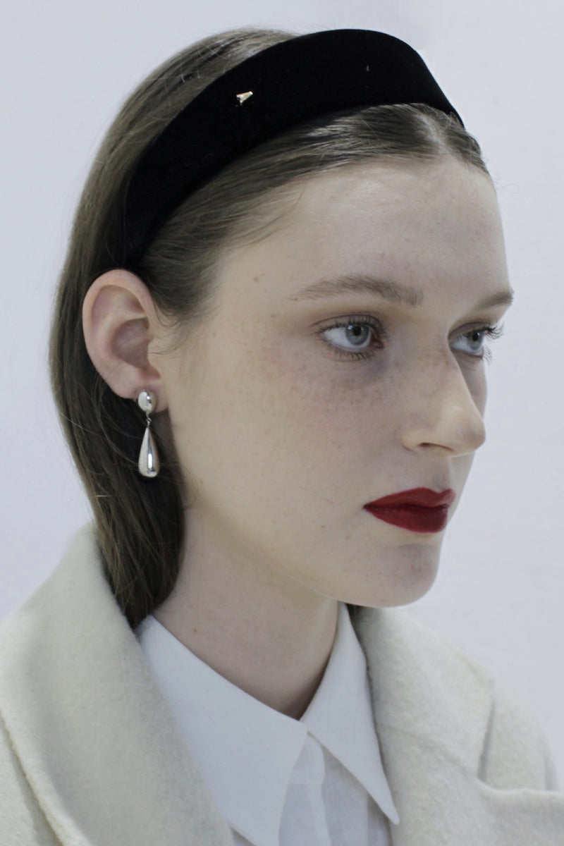 Silver toned earrings by Aethera featuring a sleek, modern design with a polished finish, showcased on a neutral background.