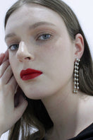 A pair of elegant MAJA earrings by Aethera featuring intricate design and silver finish, displayed on a neutral background.