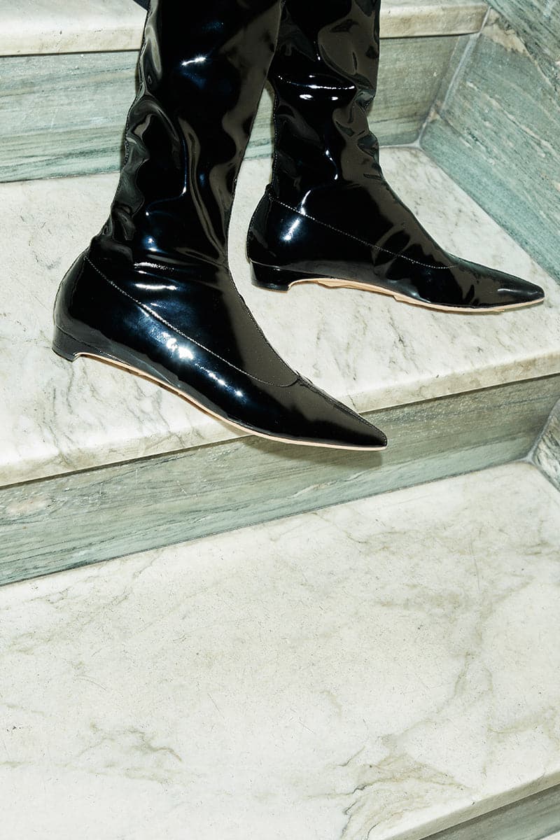 A pair of black patent-effect boots from AERA named Nicolette, featuring a sleek design and shiny finish.