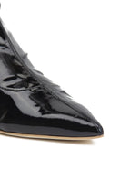 Black patent-effect boots by AERA featuring a sleek front view with a pointed toe and smooth shiny finish.