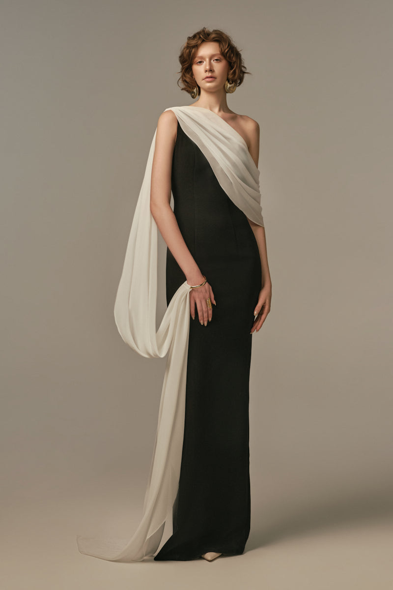 Poem Nocturne gown in white and black, elegant long gown with flowing fabric, modeled on a woman.
