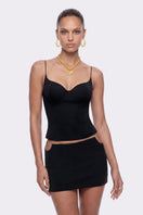 Black Noelia top by Nana Jacqueline featuring cat-eye neckline, showcased in a fashionable lookbook photo.