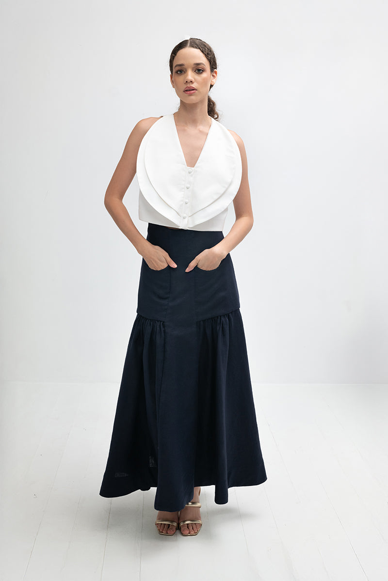 Navy blue Noelle maxi skirt by ANA + MARIA, flowy fabric with a high waist and elegant length, displayed on a hanger.