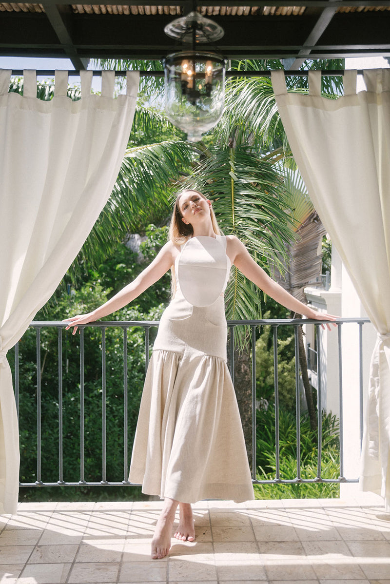Ana + Maria Noelle maxi skirt in sand, flowing fabric, styled in a campaign photo with a relaxed, elegant look.