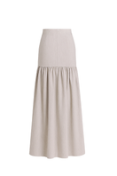 Light beige ANA + MARIA Noelle maxi skirt in sand color, flowing fabric, styled with a relaxed fit and elegant silhouette.