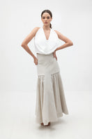 ANA + MARIA Noelle Sand Maxi Skirt displayed with flowing fabric and high waist design in a natural sand color.