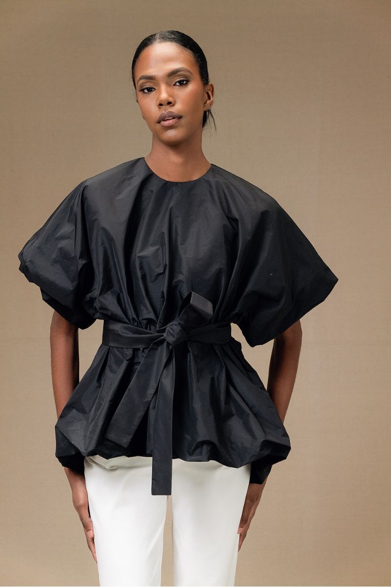 Black Nonora blouse by ANA + MARIA, stylish women's tops with a fitted design and elegant neckline on a white background.