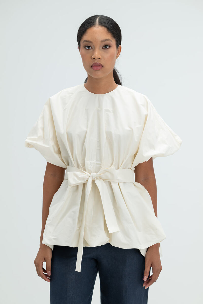 Elegant ivory Nonora blouse by ANA + MARIA featuring soft fabric and classic design, displayed on a hanger.