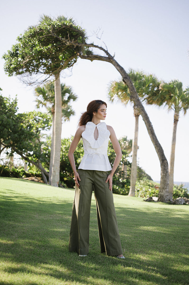 Elegant ivory Nova blouse from ANA + MARIA with a soft, flowing fabric and detailed neckline, styled as a top in a fashion campaign photo.
