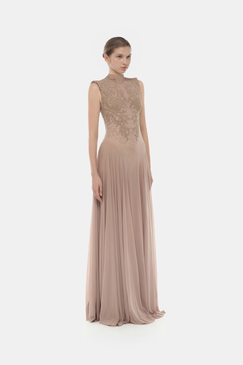 Nude sleeveless jacquard maxi dress by Montsand, flowing elegant design with intricate fabric pattern, perfect for formal occasions.
