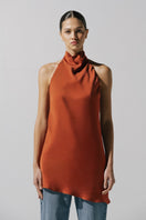 Baobab Numa top in terracotta, stylish sleeveless blouse with a relaxed fit, displayed on a hanger.