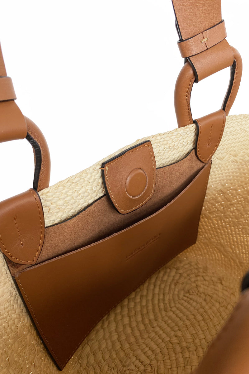 ISIDORA MALVA Nuqui Basket in tan, top handle bag made of woven material with a natural finish and sturdy top handles.