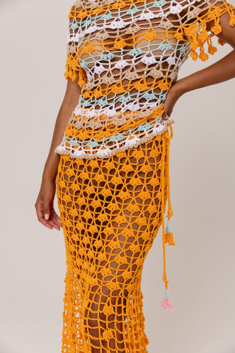 Handmade crochet top by Andreeva featuring vibrant orange and blue bird of paradise pattern, displayed on a mannequin.
