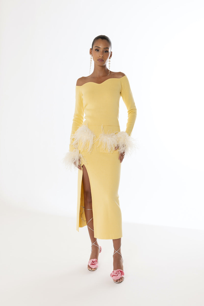 Yellow vanilla knit midi skirt with feather details by Andreeva, shown on a model against a neutral background.