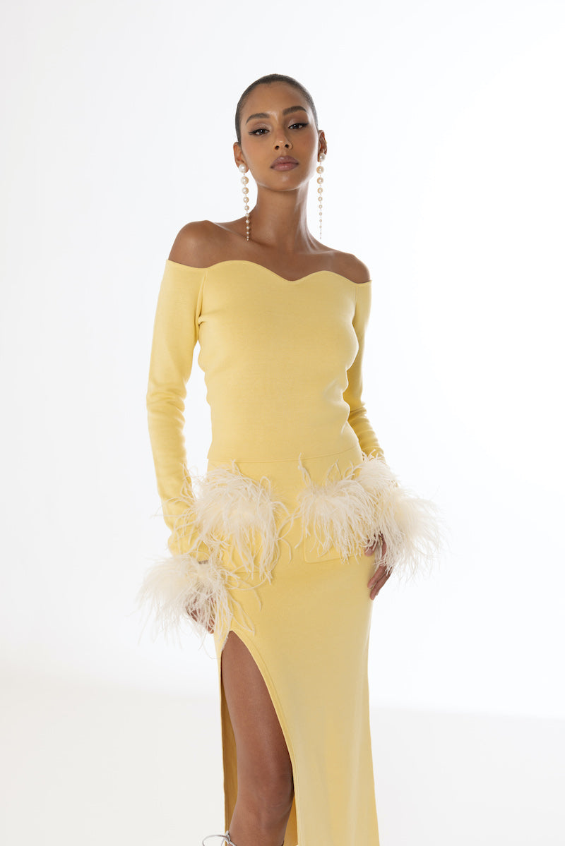 Yellow vanilla knit midi skirt with feather details by Andreeva, shown with a flowing, textured fabric design.