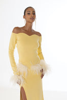 Yellow vanilla knit midi skirt with feather detailing from Andreeva, shown on a model with a flowy, stylish look.