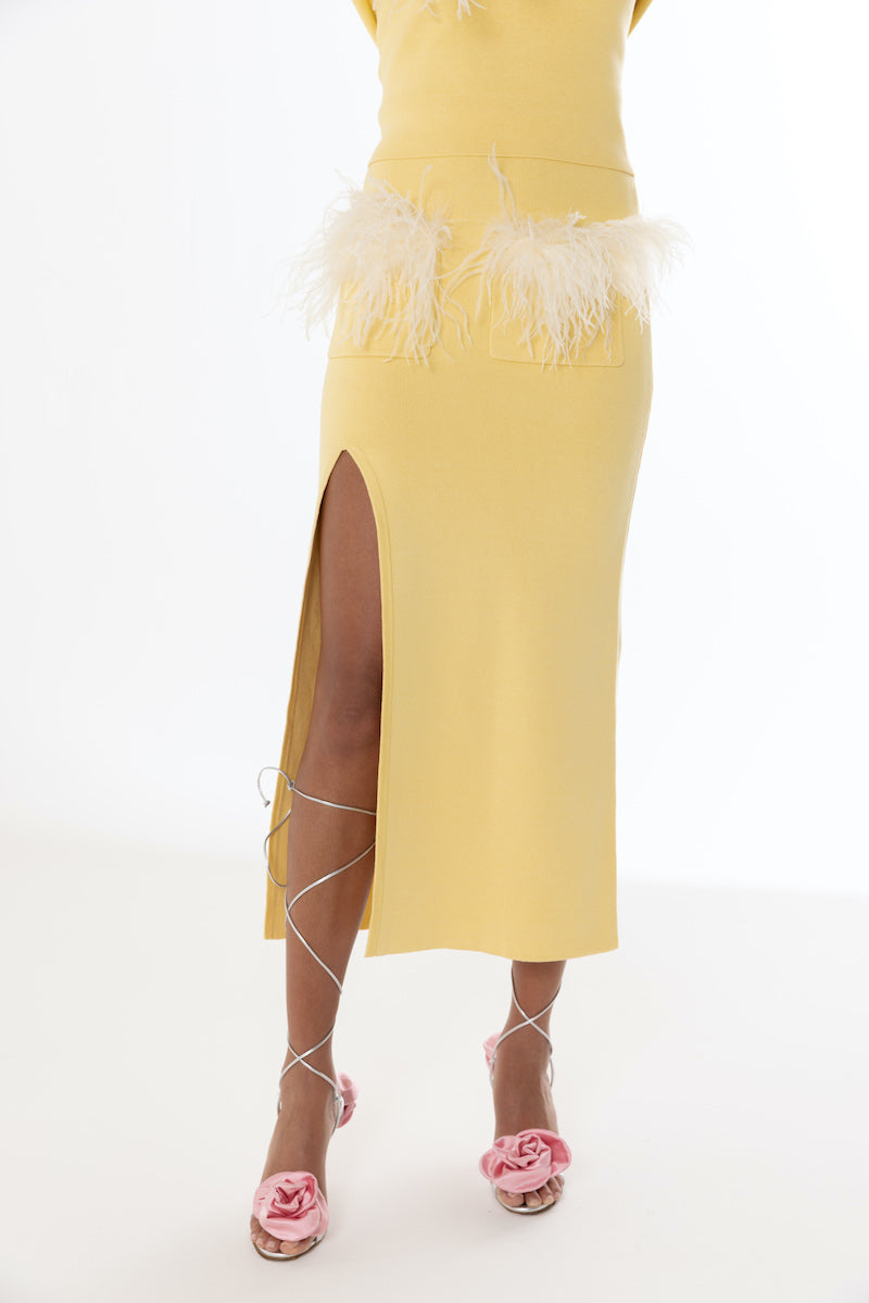 Yellow vanilla knit midi skirt with feather details by Andreeva, shown on a model, featuring a stylish, textured design.