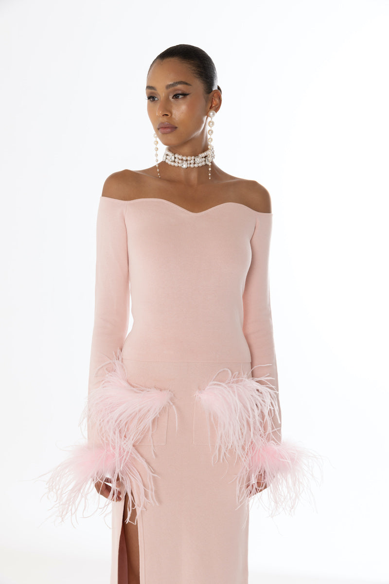 Pink vanilla knit midi skirt with feather accents from Andreeva, showing soft fabric and feather details.
